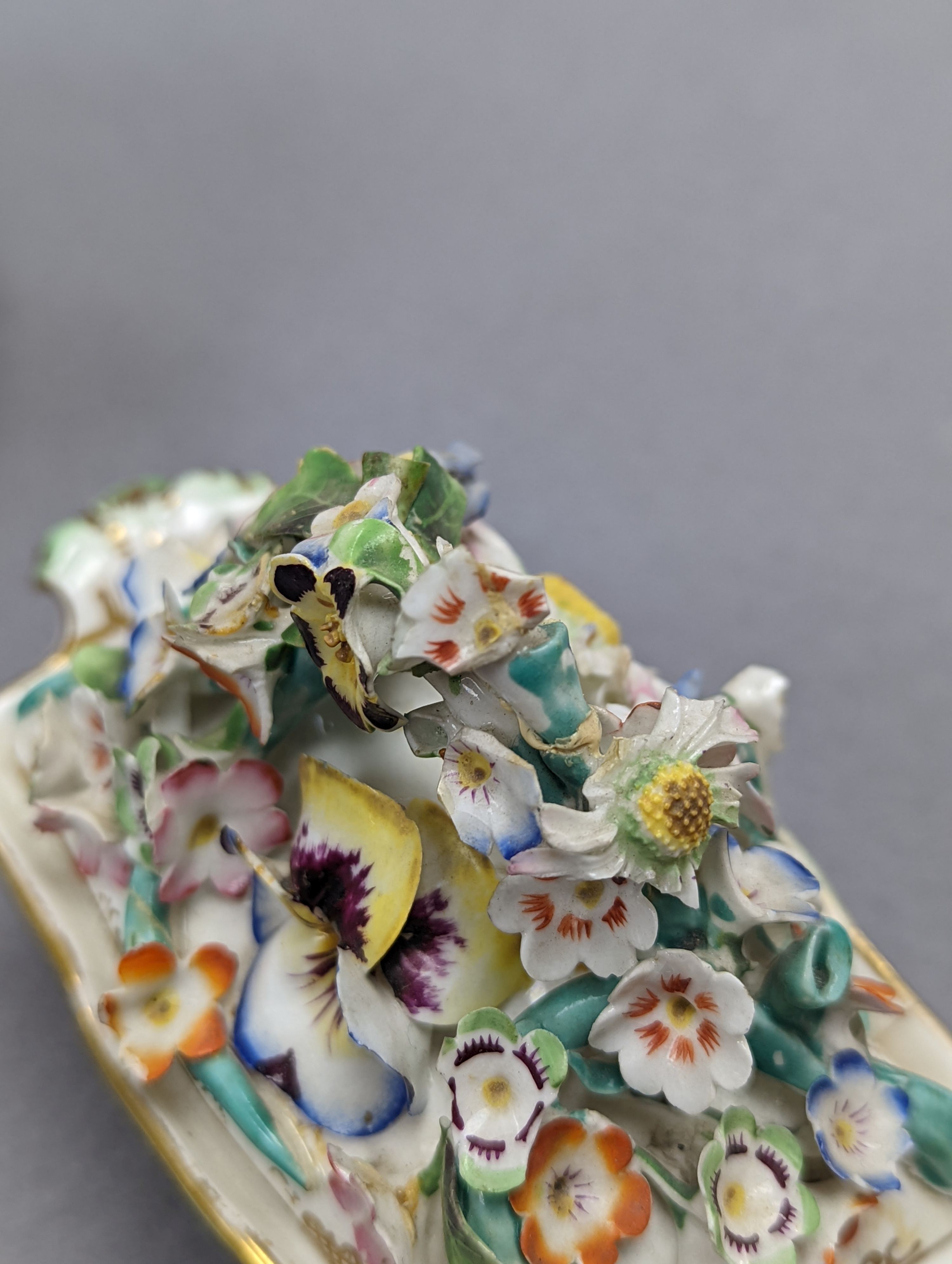 An 18th century Mennecy porcelain cup and cover, a Meissen style cup and cover, an English porcelain floral encrusted double inkwell and cover and a similar jar and cover